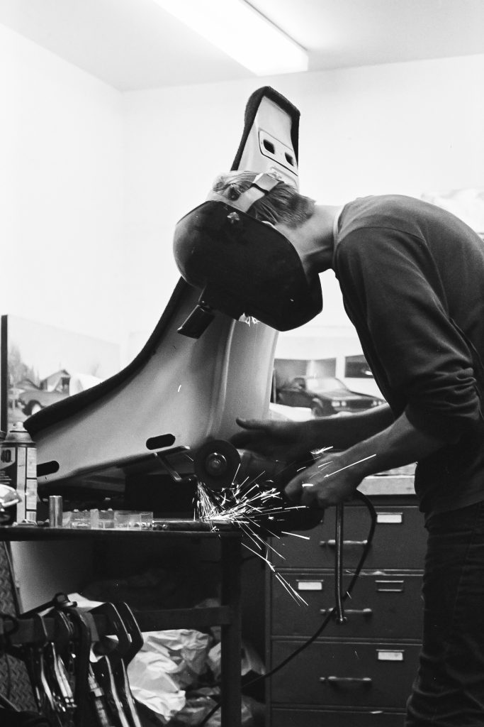 A welder wearing a protective helmet sparks as they work on metal in a workshop. Industrial repair and fabrication.