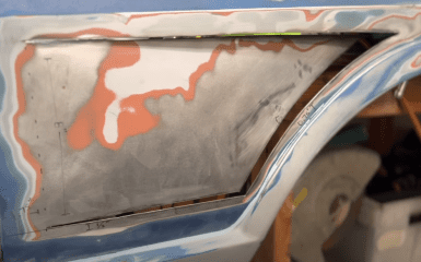 Car bodywork repair in progress, features rust removal and patch panel fitting with measurements marked in inches.