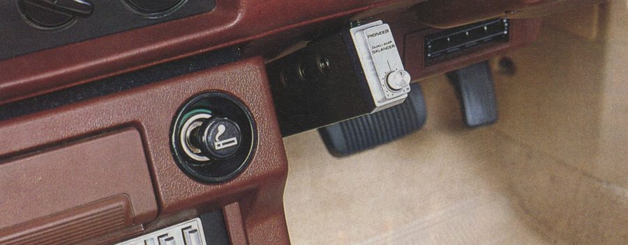 Close-up of vintage car dashboard featuring a cigarette lighter, Pioneer built-in equalizer, and foot pedals.