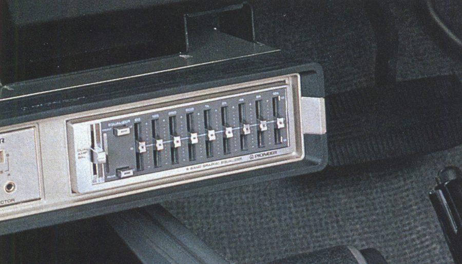Close-up of a vintage Pioneer 8-band graphic equalizer installed in a car's audio system, showcasing its sliders.