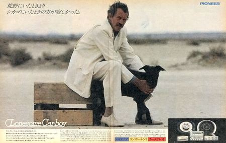 A man in a white suit sits on a bench in a desert, holding a black dog, next to Pioneer audio equipment. Text: Lonesome Carboy.