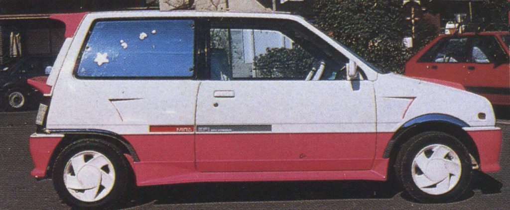 Side view of a white and pink Daihatsu Mira TR-XX Avanzato kei car; features a sporty design and custom decals.