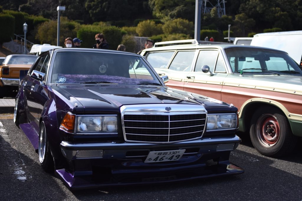 Classic dark purple Japanese car with license plate 姫路330 る46-49 at a vintage car show, surrounded by other vintage cars.