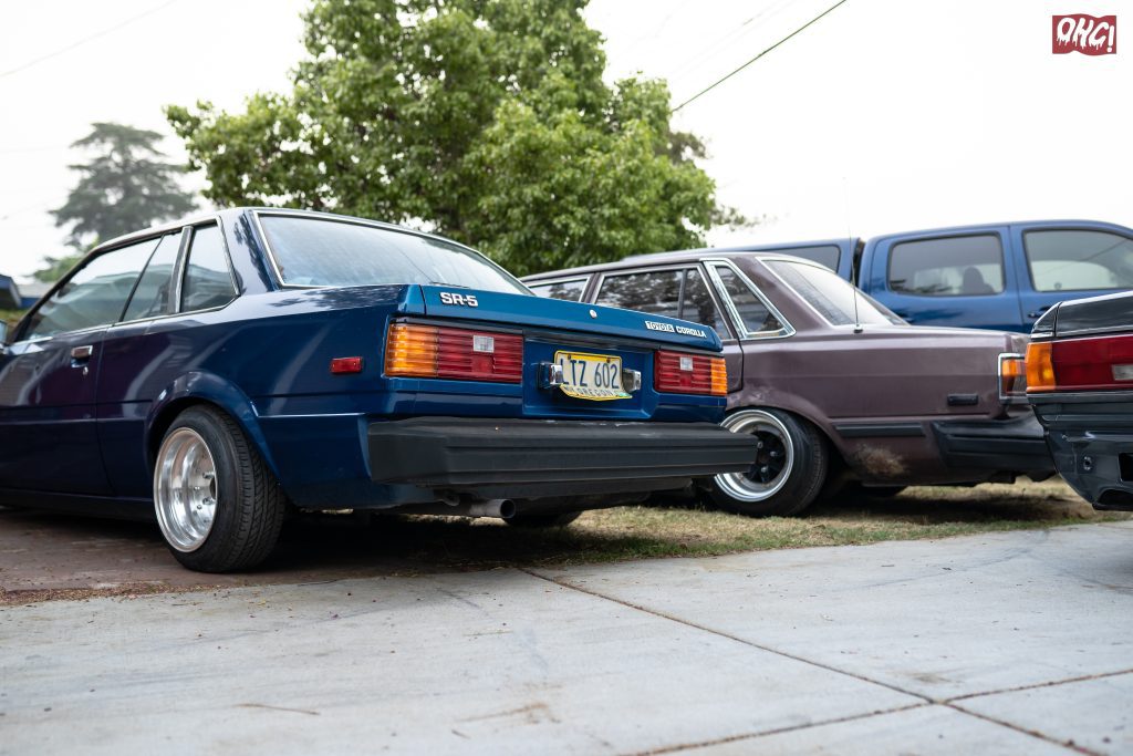 Rear view of classic Toyota Corolla SR5 cars lined up in a driveway.