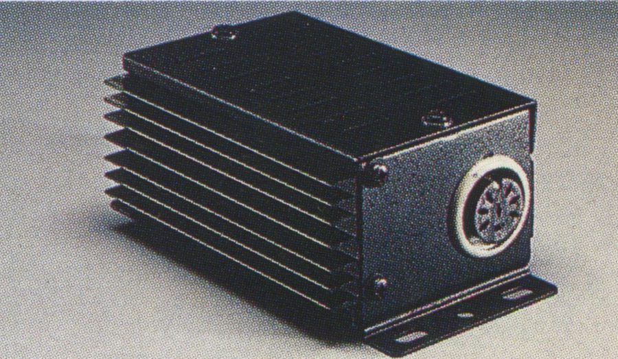 Black anodized aluminum heat sink for electronic equipment with a circular connector, isolated on a grey background.