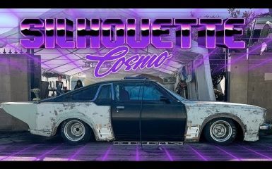 Modified classic car under a canopy with neon text Silhouette Cosmo above, highlighting custom automotive restoration.