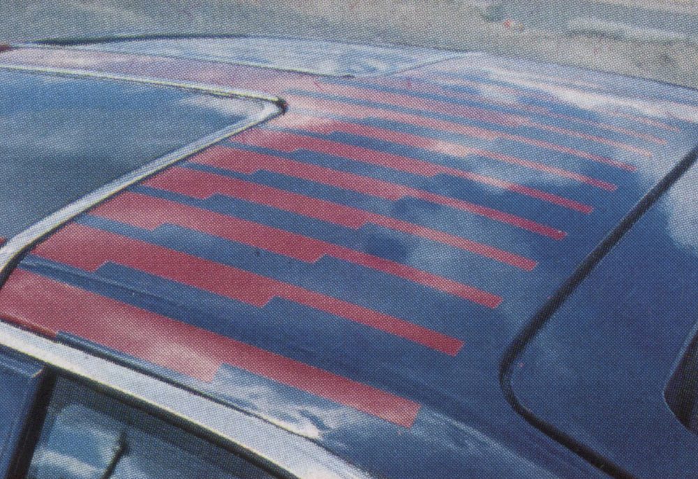 Close-up of a car roof with red stripes and blue paint reflecting the sky and clouds.