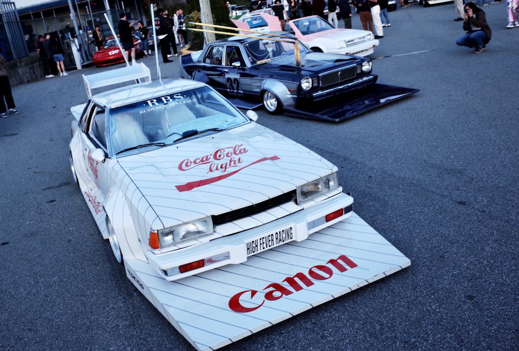 Custom Toyota car with Coca-Cola Light and Canon branding at a Japanese car meet, featuring unique modifications.
