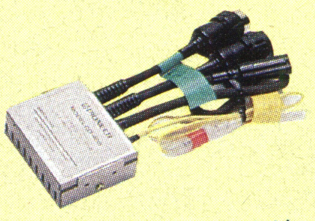 Alt text: Electronic device with multiple black cables and connectors on a yellow background.