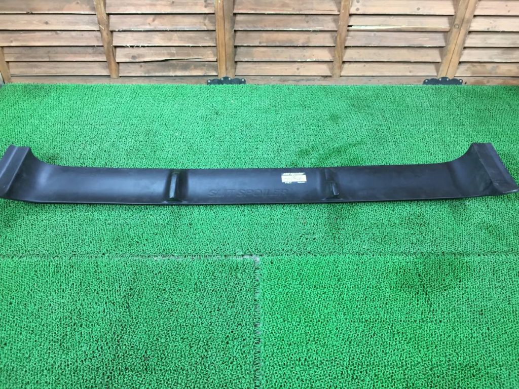 Alt Text: Black car bumper on a green mat with SILVIA S14 and Japanese text visible on the bumper in wooden background.