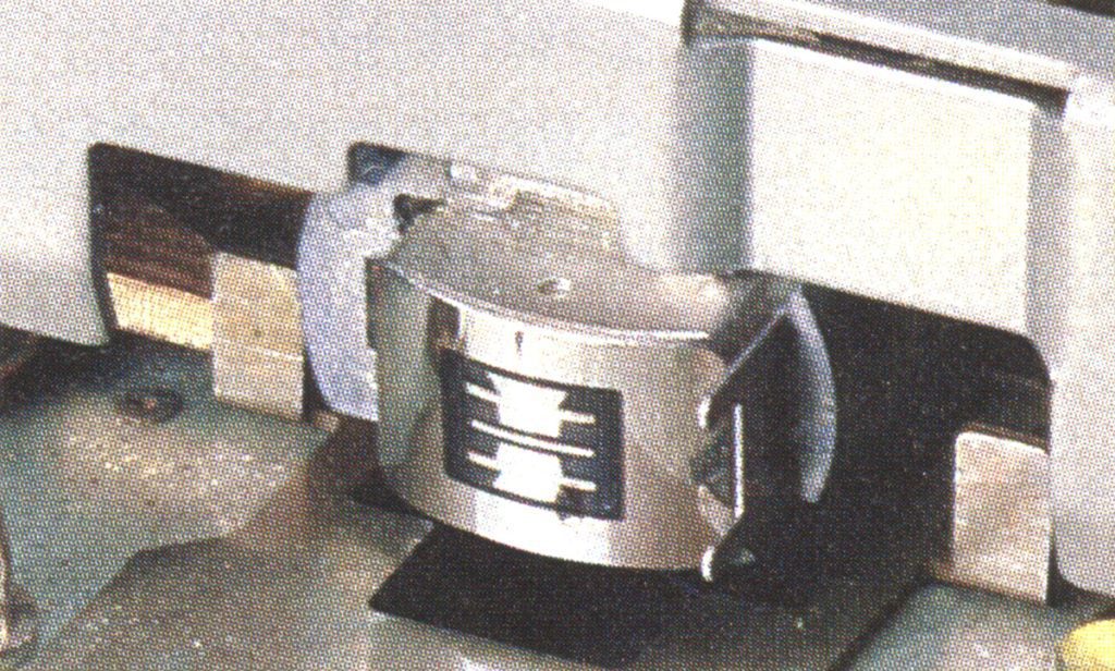 Close-up of a mechanical component with Japanese text '上下' (up and down) on a metal part in an industrial setting.