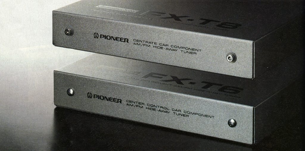 Two Pioneer FX-T6 car AM/FM hide-away tuner components stacked on a black surface