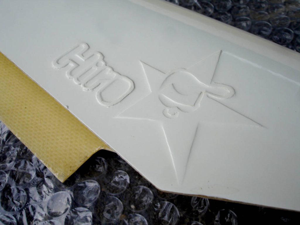 Close-up of a product with Hiro and star logo embossed on white plastic, set against bubble wrap.