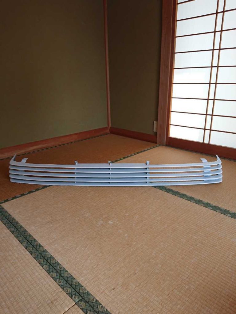 Alt Text: White front grille panel placed on a tatami mat inside a traditional Japanese room with shoji screen.