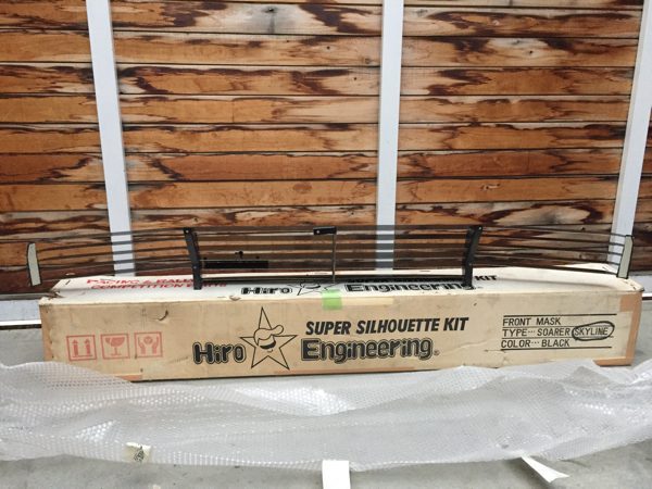 Hiro Super Silhouette Kit Engineering Front Mask for Soarer Skyline, Black color, in packaging, against wooden background.