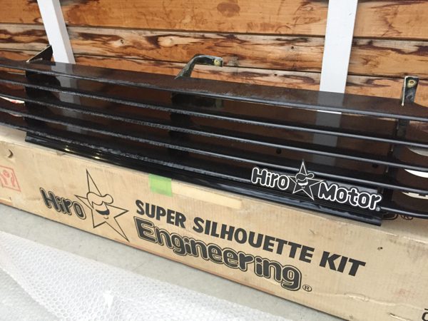 Hiro Motor Super Silhouette Kit Engineering boxed on floor with black car part placed above the cardboard package.
