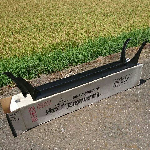 Hiro Engineering car spoiler kit on a box labeled Super Silhouette Kit with a grassy field in the background.
