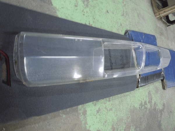 Clear plastic canopy with partially visible Japanese text on a workshop floor, likely for a scale RC airplane model.