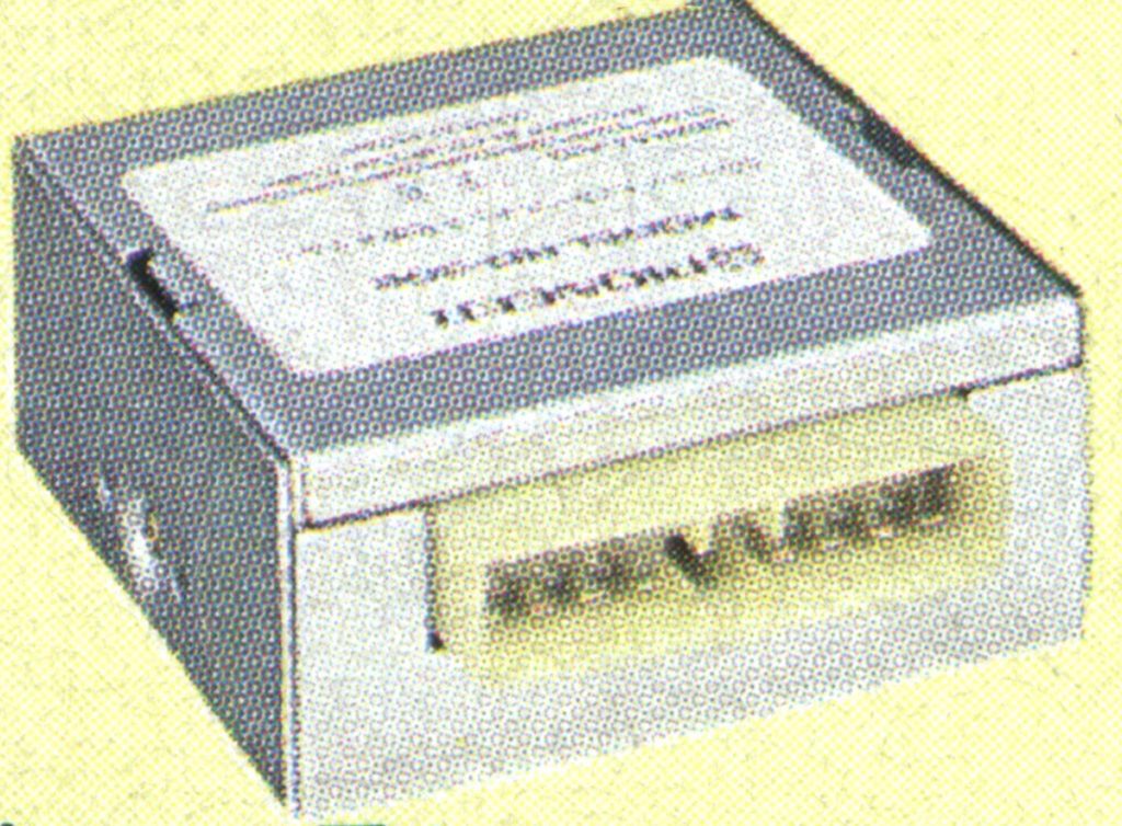 Alt text: Small square metal box with Japanese text, labeled as 'Famicom.'Note: Only the most pertinent details are included to stay within 125 characters while maintaining SEO-friendly keywords.