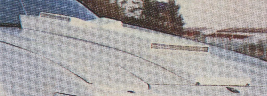 Close-up view of a futuristic white vehicle with sleek design lines in an outdoor setting.