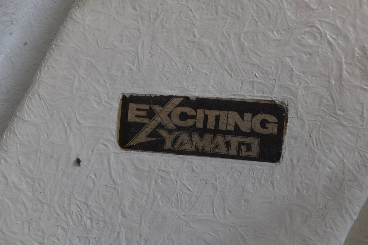 Old Exciting Yamato sticker on textured white surface