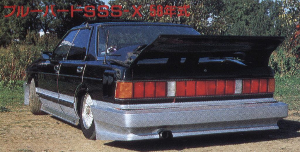 1983 Nissan Bluebird SSS-X with body kit and rear spoiler, parked outdoors. Japanese text says Bluebird SSS-X, 58th year model.