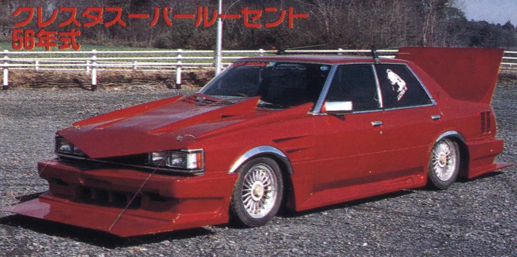 Red modified Cresta Super Lucent 58 style with aggressive body kit and custom rims in an outdoor setting.