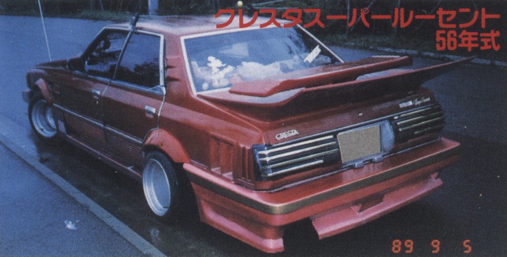 Rear view of a modified 1981 Cresta Super Lucent car with a wide body kit and large rear wing. Text: Cresta Super Lucent 56.