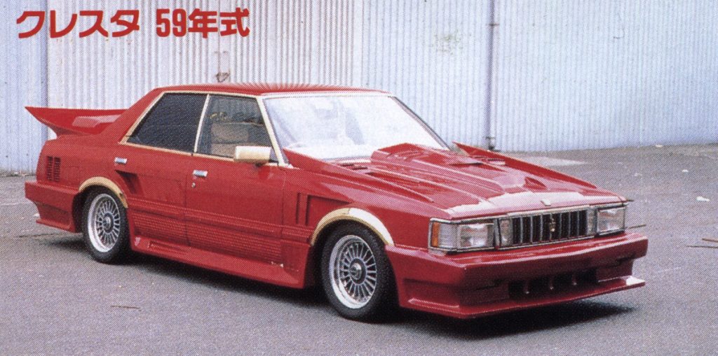 Red modified Toyota Cresta 1984 (59年式) with aerodynamic body kit and spoiler, parked by a metal wall.