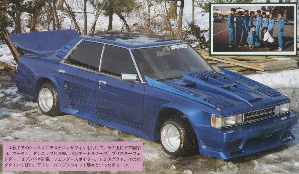 Modified blue 4-door sedan with sports tuning and Testarossa fins; inset shows racing team in blue uniforms in snowy setting.