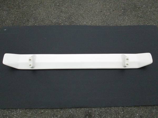 Front view of a white car bumper reinforcement bar displayed on a dark surface, suitable for automotive use or repair.