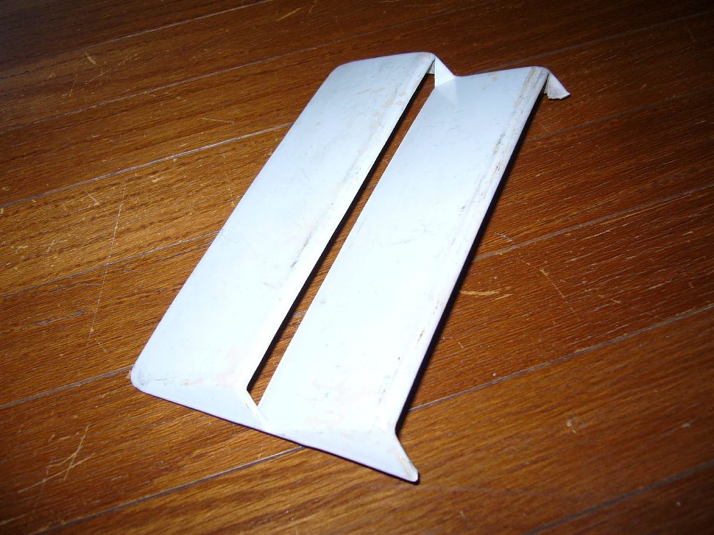 Rusty white metal tool on wooden surface.