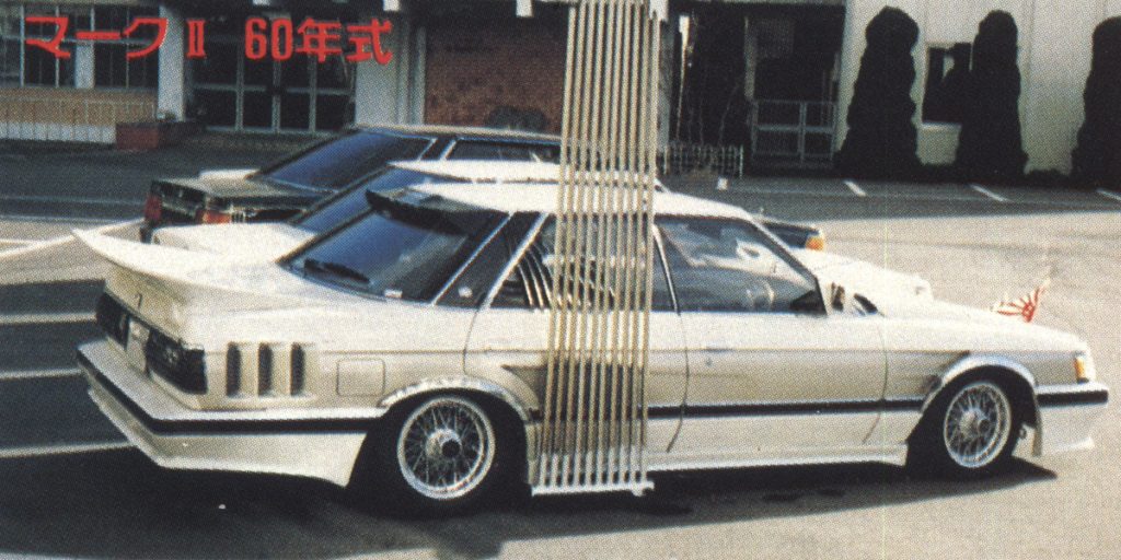 Two modified vintage Japanese cars parked outside. Text マーク II 60年式 translates to Mark II 1985 model.