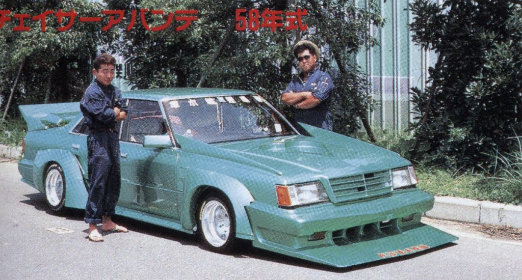 Two men standing next to heavily modified green car. Japanese text translates to Chaser Avante, 58-year model.
