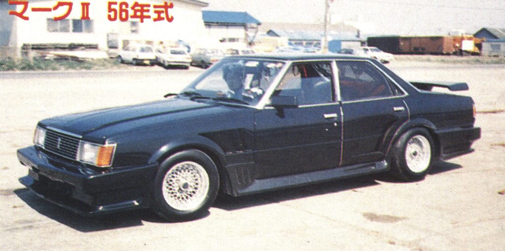 Vintage customized black Mark II car from 1981, parked outdoors; Japanese text on image translated as Mark II 56 years.