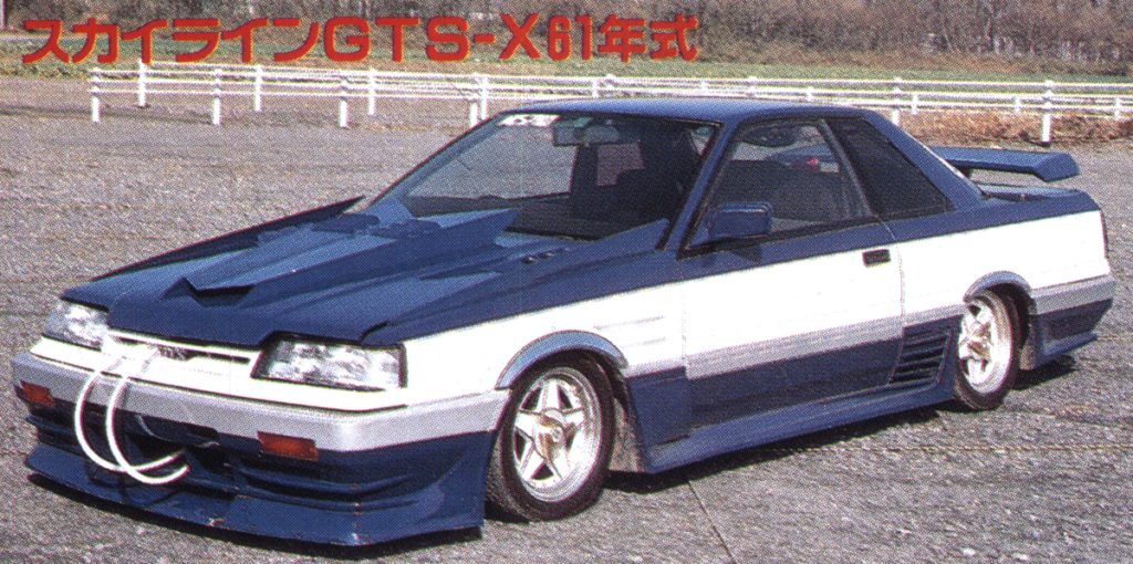 Modified 1981 Skyline GTS-X in blue and white color scheme in an outdoor setting, Japanese text reads Skyline GTS-X 1981 model.