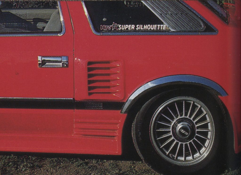 Close-up of a red Hiro Super Silhouette car, showing detailed side panel and wheel with pronounced fender.