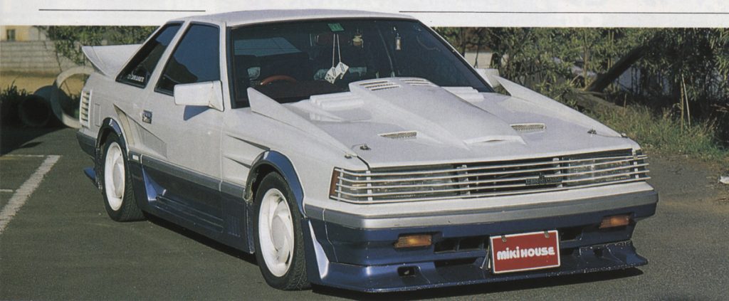 Vintage Japanese sports car with custom body kit and MIKI HOUSE license plate parked on the street.