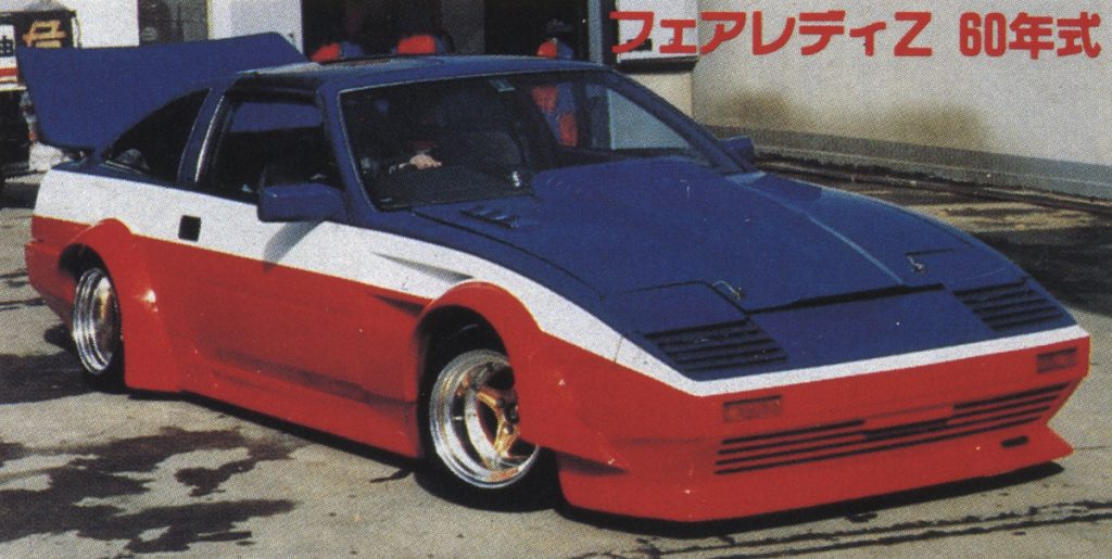 Modified Nissan 300ZX Fairlady Z 1985 with red, white, and blue custom paint job, Nissan Fairlady Z S30 Works fender and aftermarket wheels. Japanese text reads Fairlady Z 60-Year Model.