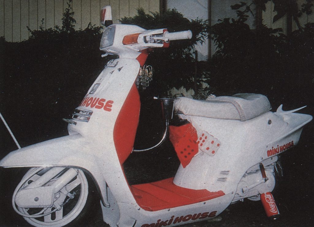 Vintage white and red scooter with Miki House branding, featuring a Coca-Cola can attached to the frame.