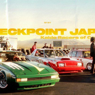 Custom Japanese sports cars and racers at Checkpoint Japan event in California with mountain backdrop.