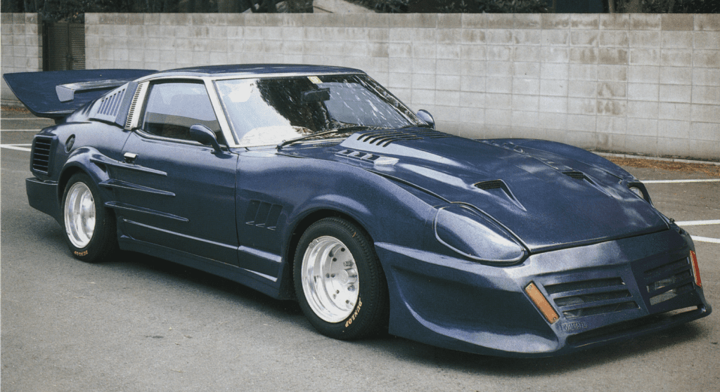 Modified blue Nissan 280ZX sports car with wide fenders, large rear wing, and custom body kit parked near concrete wall.