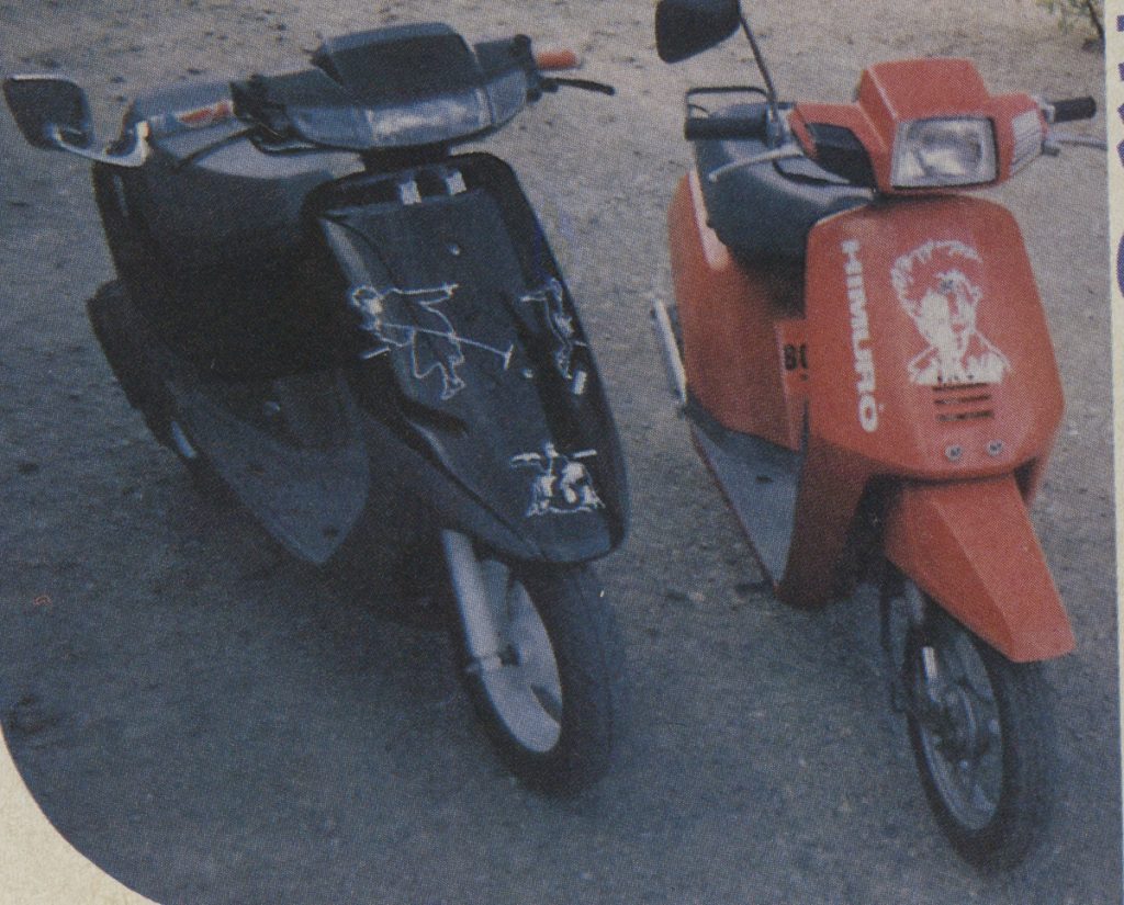 Two customized scooters, a Honda Dio and a Honda Pax, parked on a pavement, featuring decals and graphics. Japanese text on the red scooter reads Kimagure.