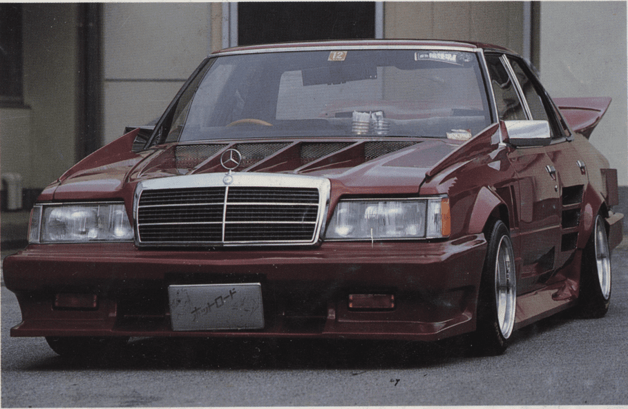 Customized vintage Toyota GX61 Mark ii with aggressive body kit, Mercedes Benz grille, and low stance; Japanese license plate reads ナツロード meaning Nat Road.