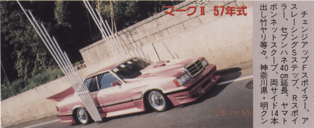 Pink modified Toyota GX61 Mark ii car with extended vertical takeyari exhaust pipes, parked on the street. Japanese text describes custom features.