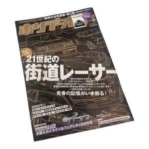 Japanese car magazine cover featuring street racers of the 21st century with futuristic vehicle sketches.