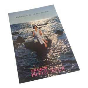 Vintage Japanese Hi-Fi car stereo ad with person sitting on rocks in the ocean. Text: A new world of sound for your ears.