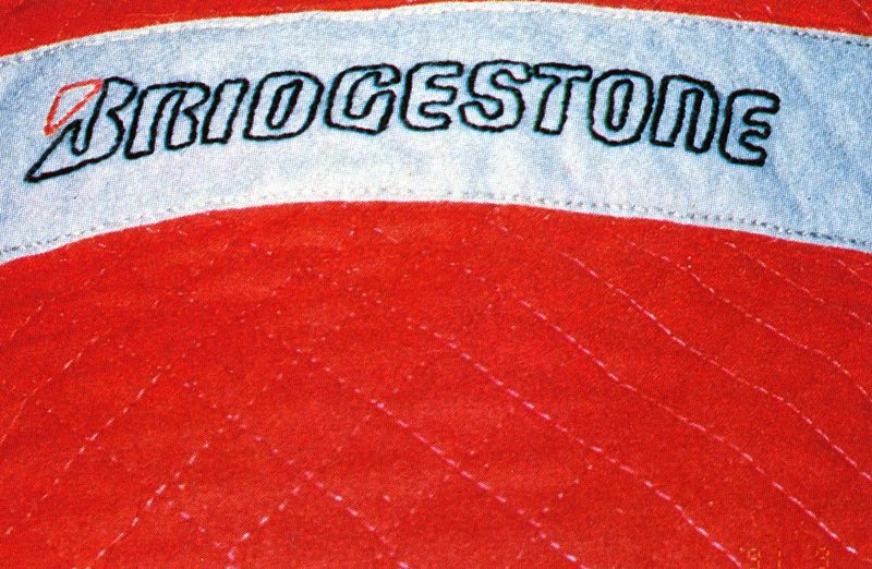 Red Bridgestone logo on a quilted fabric background.