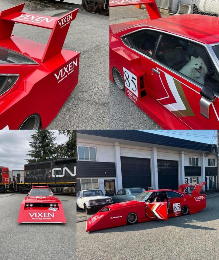 Red racing car with number 85 and VIXEN logos, featuring bold aero kit and a dog inside, parked near industrial buildings.