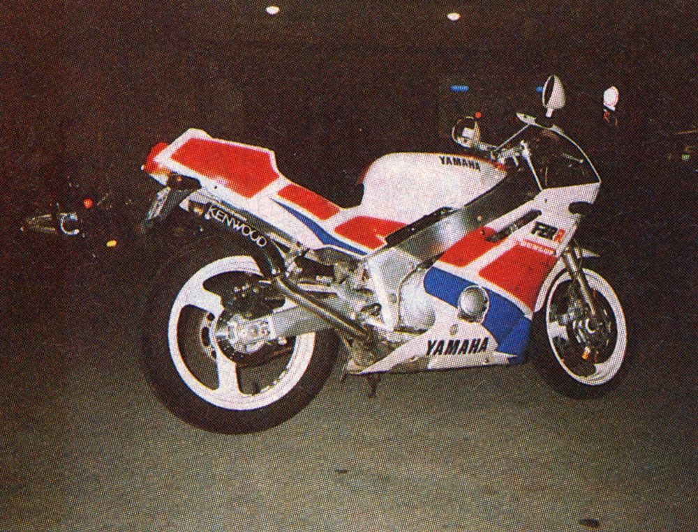 Classic Yamaha FZR motorcycle with red, white, and blue racing colors, parked at night.